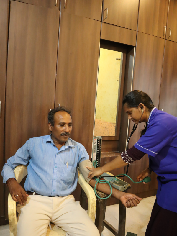 female nurse taking Bloodpressure from patient
